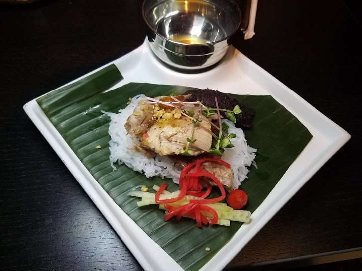 A plate of food on a leaf with rice and vegetables.