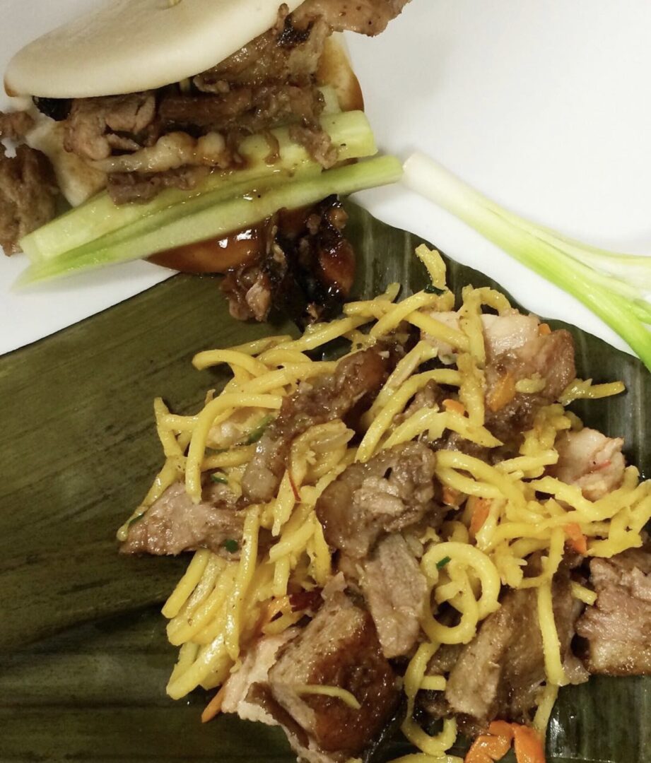 A plate of food with meat and noodles on it.