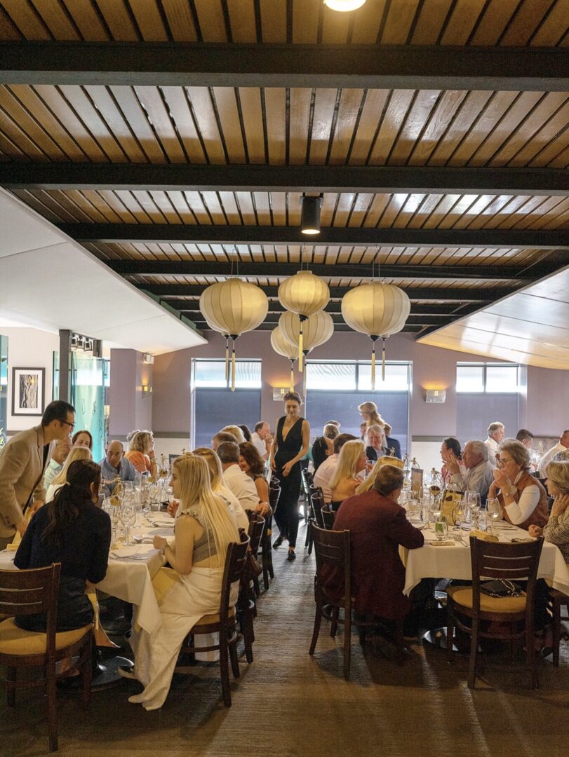 A group of people sitting at tables in a restaurant.