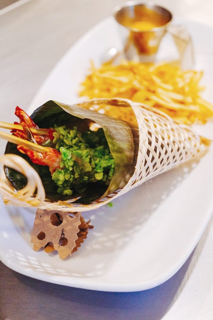 A cone filled with food on top of a white plate.