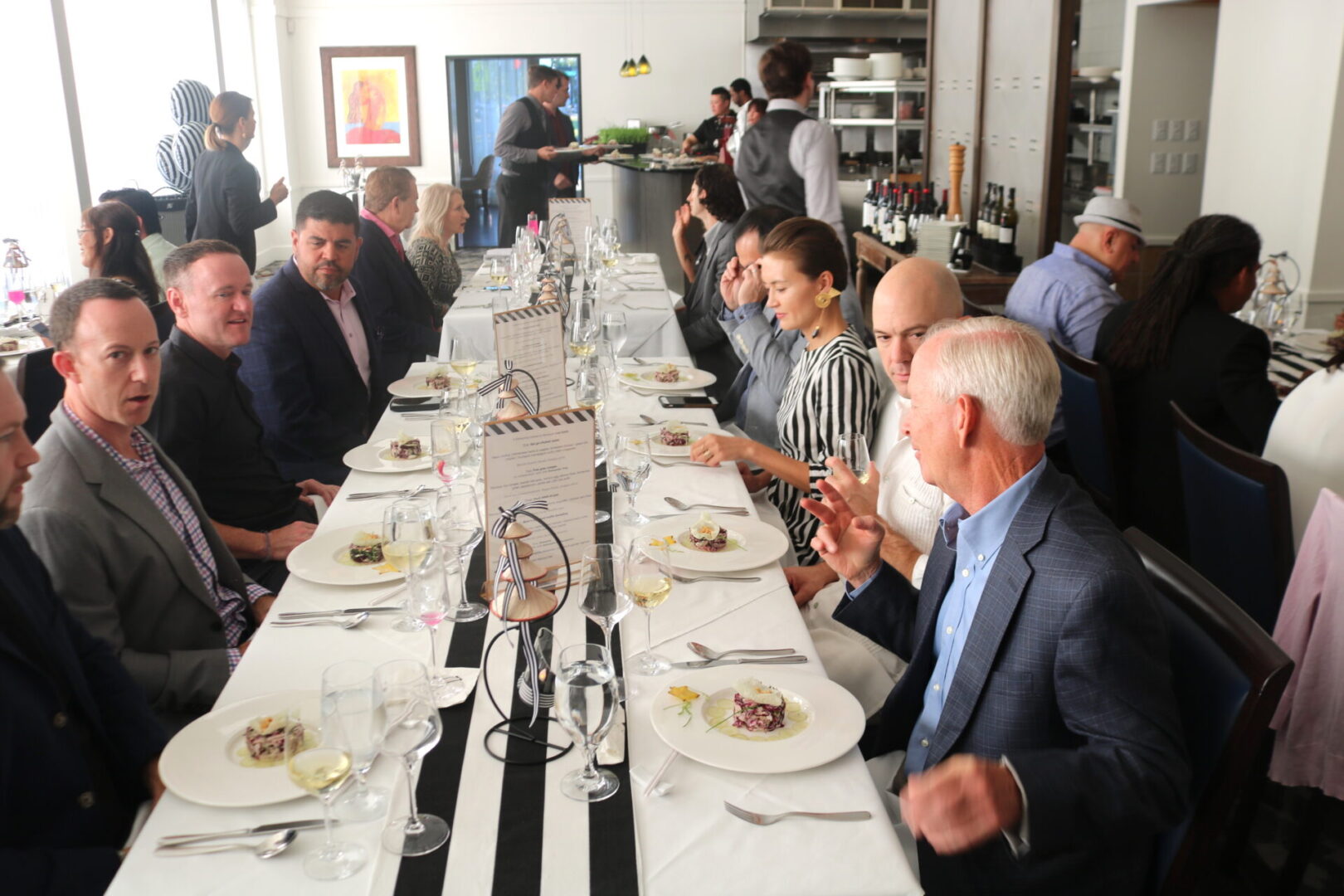 A group of people sitting at a long table eating.