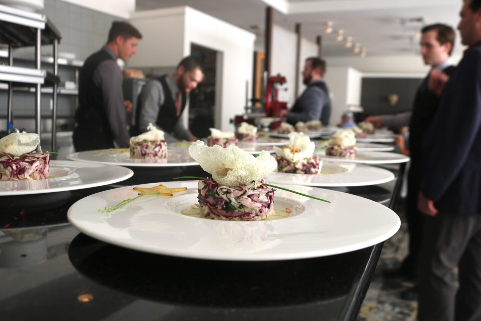 A group of people standing around plates with food on them.