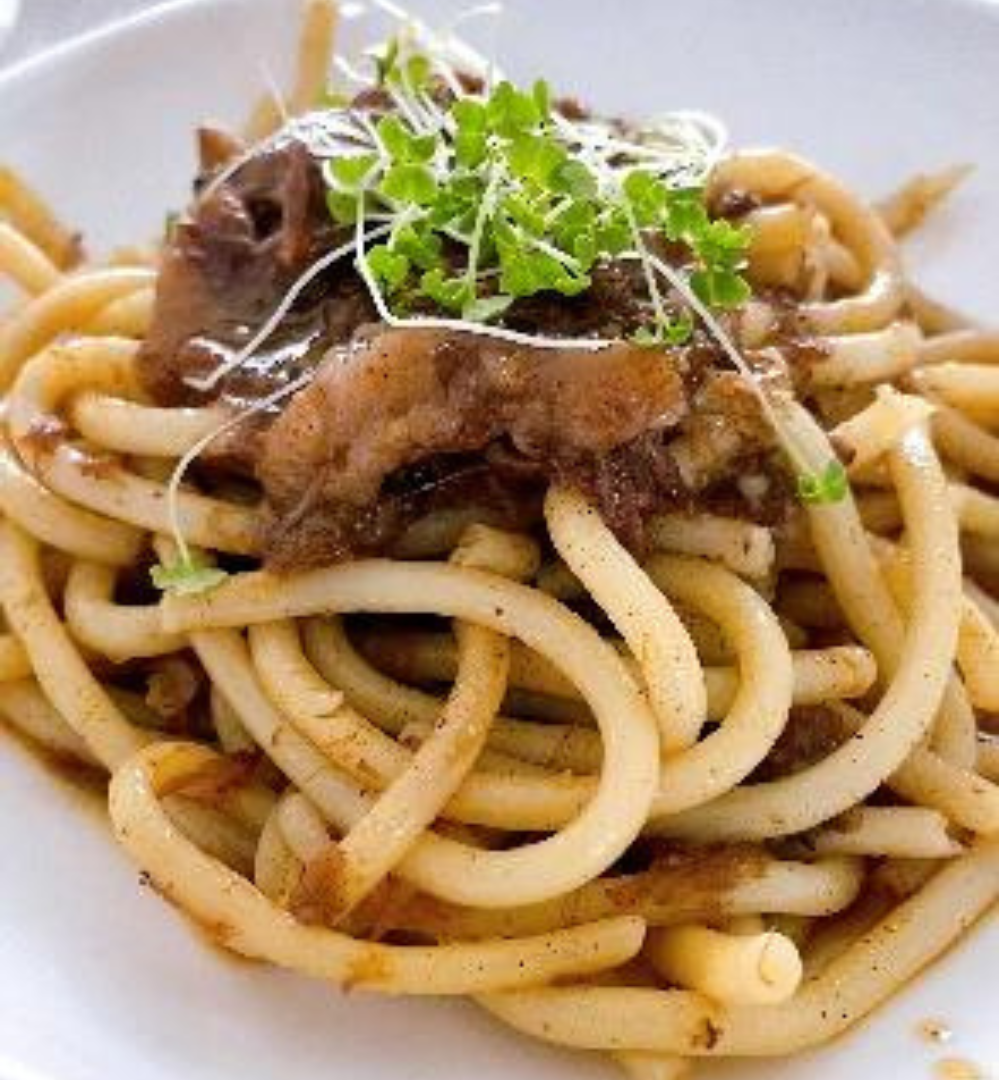 A plate of pasta with meat and sauce.