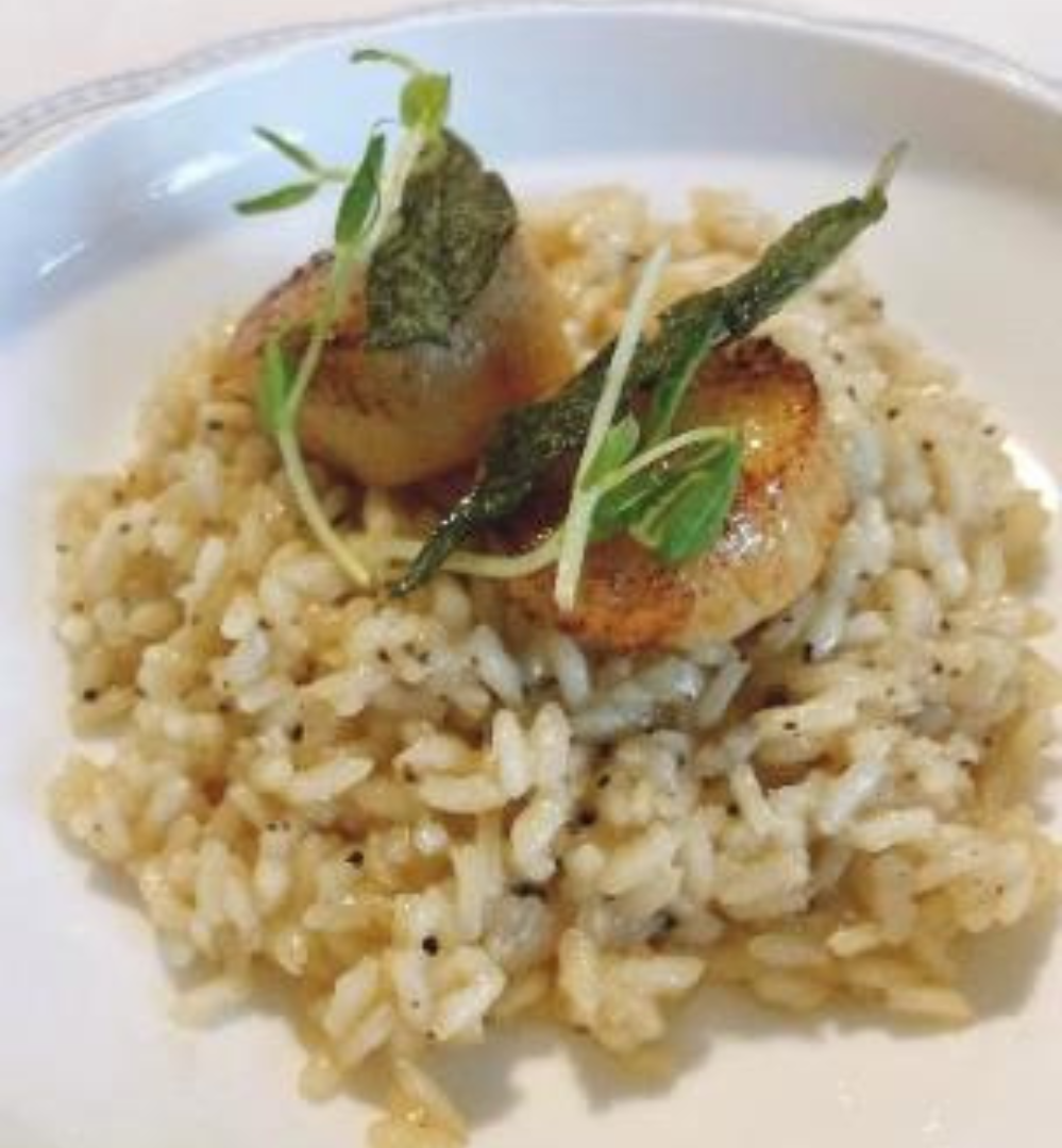 A plate of food with rice and scallops.