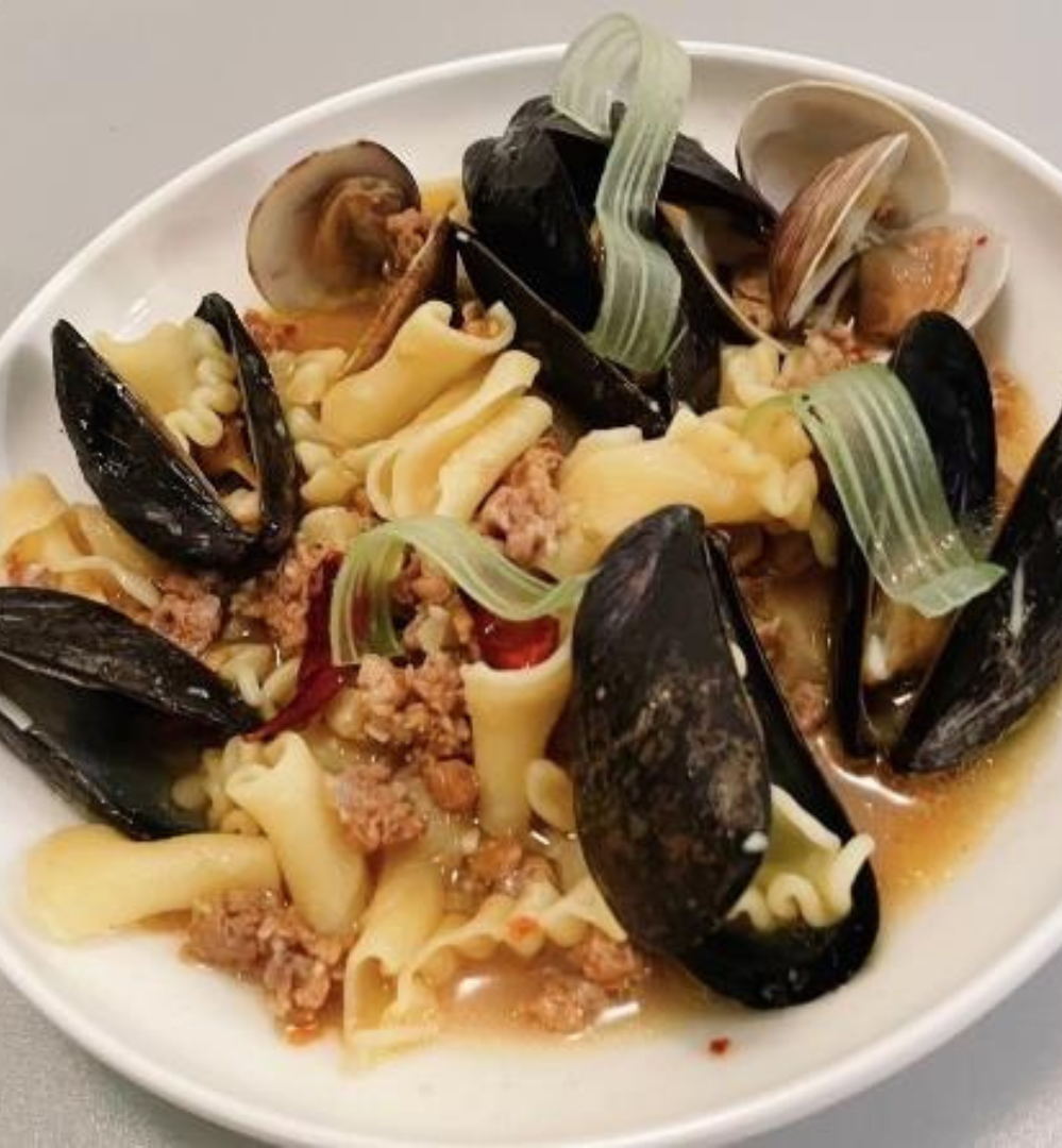 A plate of pasta with clams and meat.