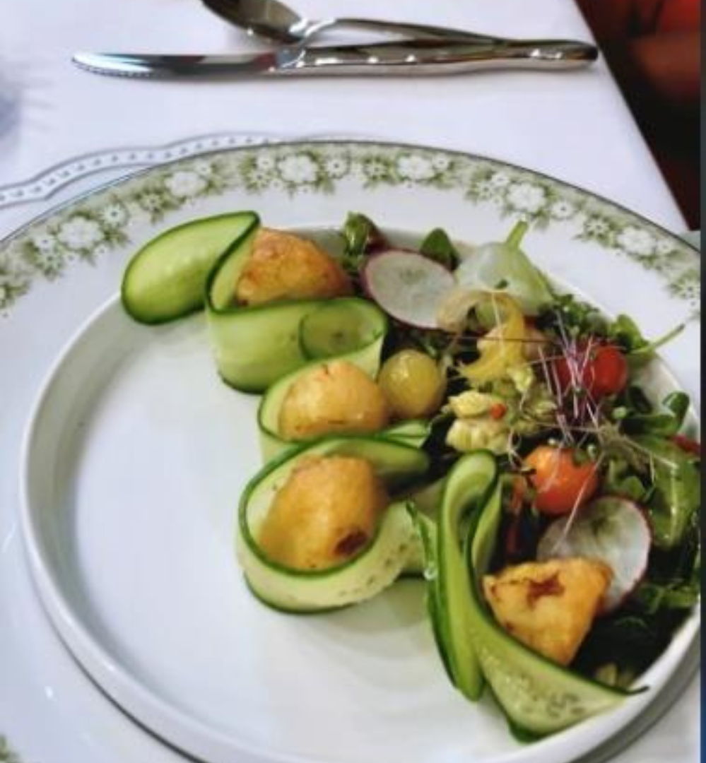 A plate of food with cucumbers and other vegetables.